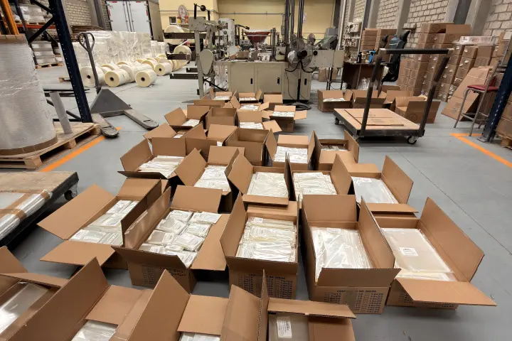 Cajas abiertas con paquetes de bolsas de celofán listos para surtir
